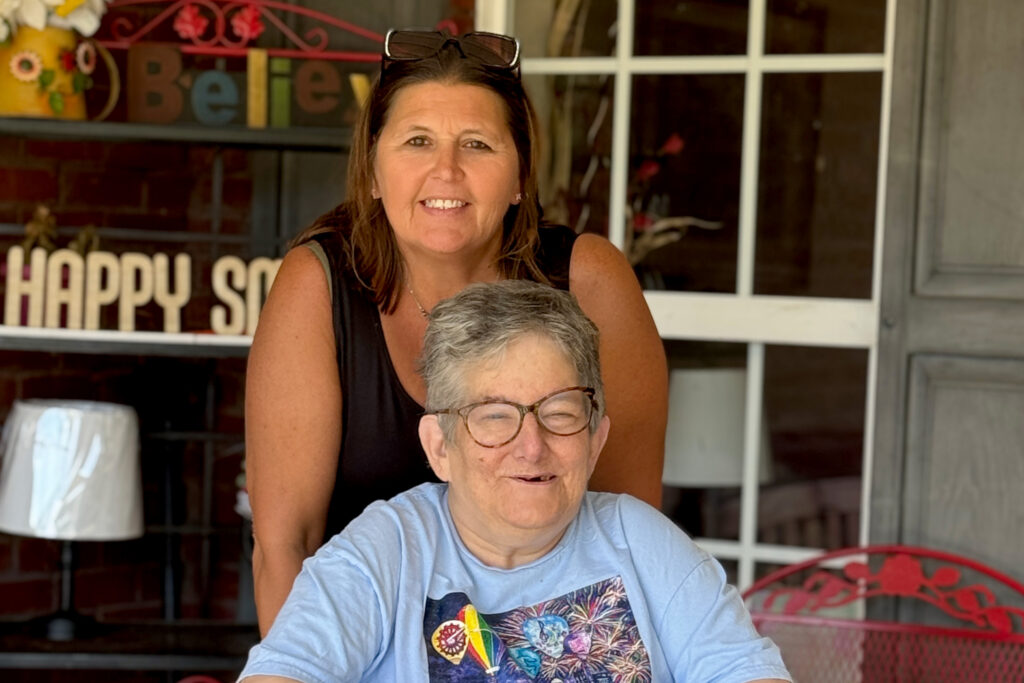 Two women smile looking at camera